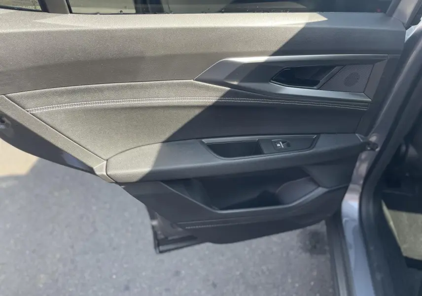 Détail de la porte arrière droite gris foncé de la Renault Rafale 2025 avec surpiqûres argentées et poignée intégrée.