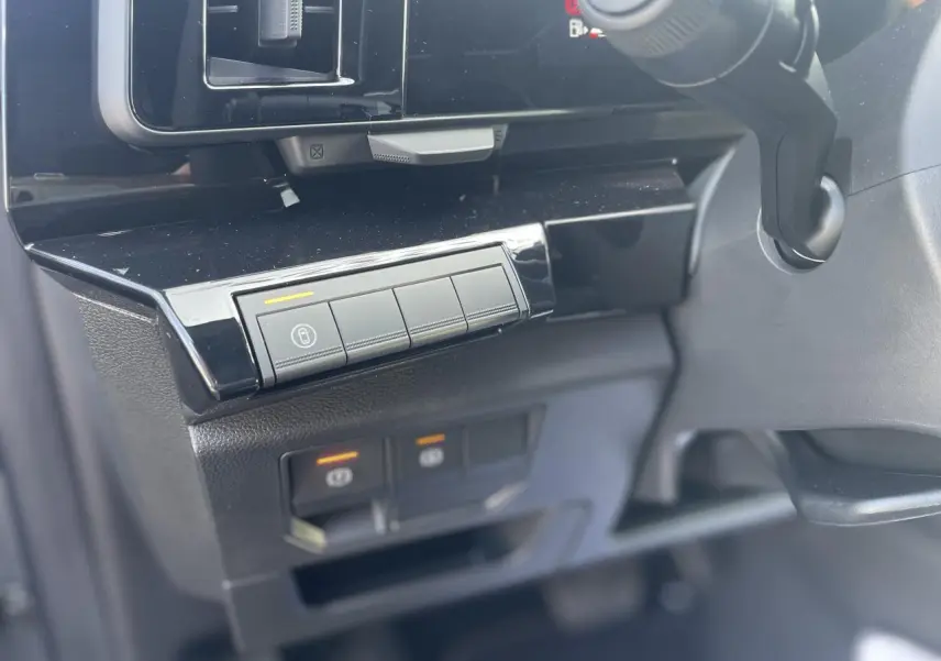 Détail du tableau de bord noir brillant côté gauche avec commandes électroniques du Renault Rafale hybride 2025.