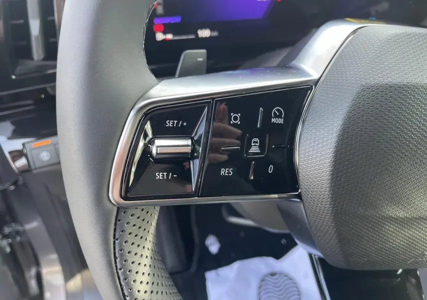 Gros plan sur les commandes de régulateur de vitesse au volant textile refined de la Renault Rafale 2025.