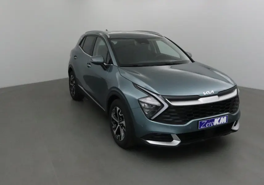 KIA SPORTAGE gris Sirius vu en 3/4 avant droit, avec calandre noire et feux LED en forme de flèche.