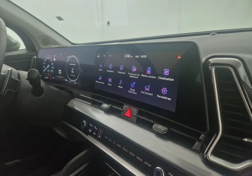 Vue rapprochée du tableau de bord digital 12,3'' du Kia Sportage gris Sirius 2025 avec écran tactile et commandes intégrées.
