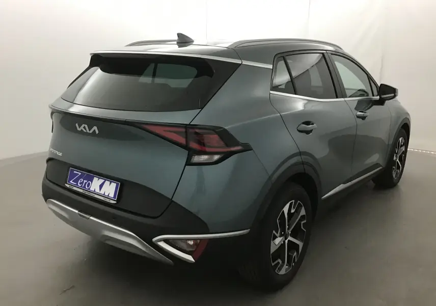 Vue 3/4 arrière droite d'un Kia Sportage gris Sirius 2025 avec jantes alliage et feux LED distinctifs.