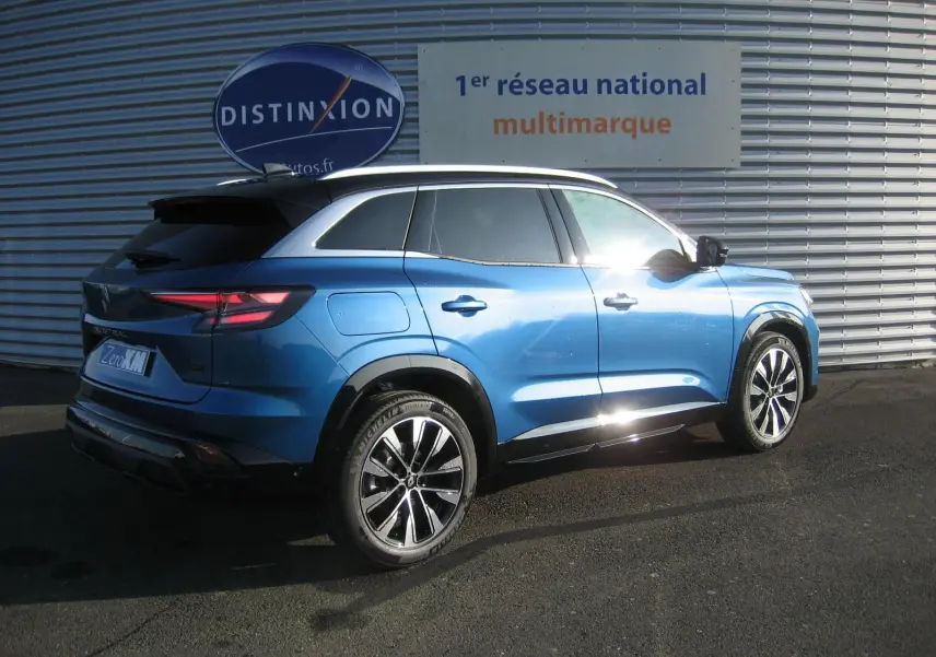 Vue 3/4 arrière droite du Renault Austral 2025 bleu outremer avec toit noir, soulignant ses jantes et lignes dynamiques.