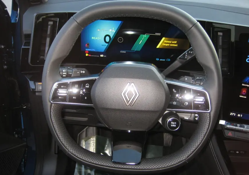 Vue rapprochée du volant multifonction noir du Renault Austral 2025 avec tableau de bord numérique allumé.