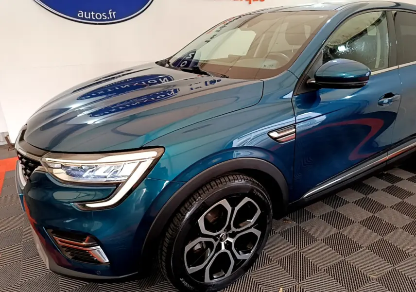 Vue 3/4 avant droit du Renault Arkana bleu, mettant en valeur ses phares LED et ses jantes alliage distinctives.