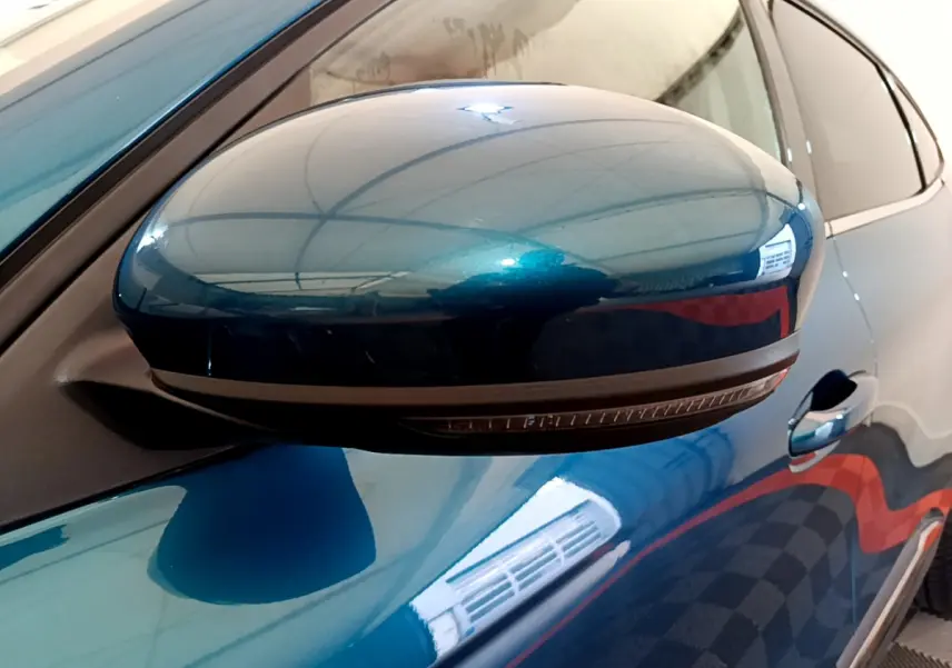 Rétroviseur côté gauche bleu métallisé de la Renault Arkana Techno E-Tech 2023 avec clignotant intégré.