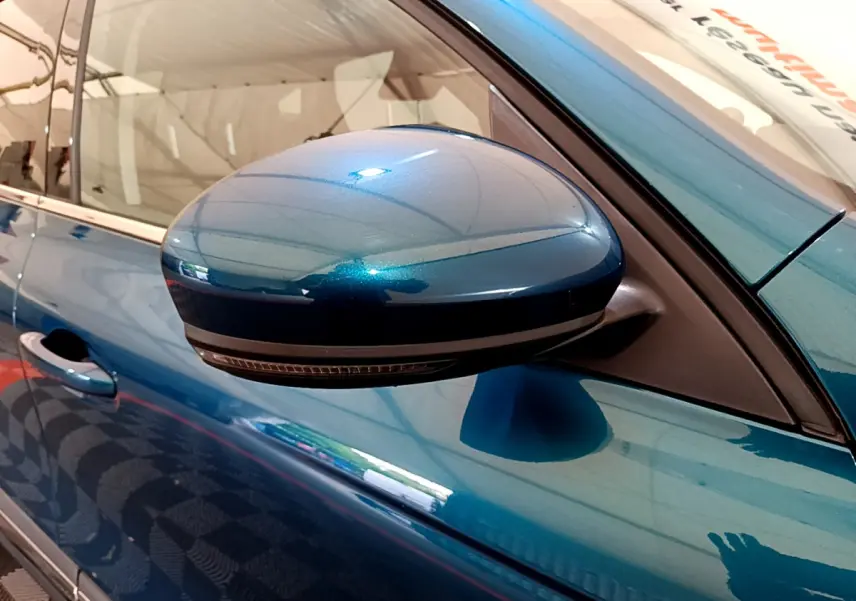 Rétroviseur côté gauche bleu métallisé de la Renault Arkana Techno E-Tech 145, vue rapprochée sur la portière.
