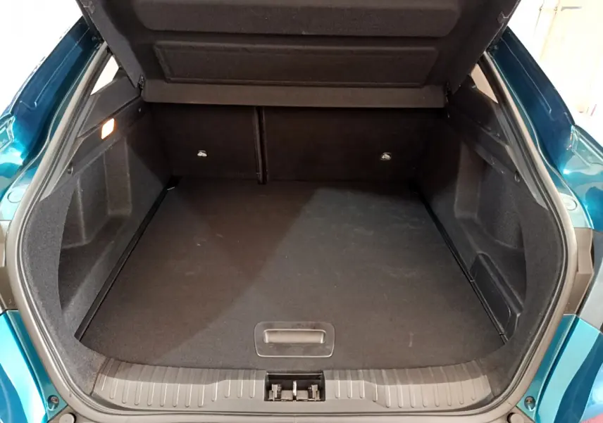 Coffre ouvert vu de l'arrière d'une Renault Arkana 2023 bleu, montrant un espace de rangement spacieux et propre.