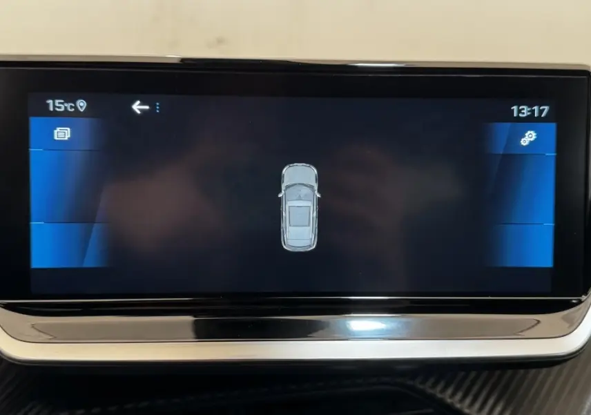 Écran tactile central affichant la vue top-down du véhicule Peugeot 2008 gris foncé, tableau de bord intérieur.