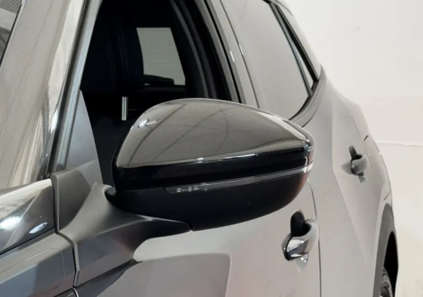 Gros plan sur le rétroviseur droit noir brillant du Peugeot 2008 gris foncé, vue latérale arrière.