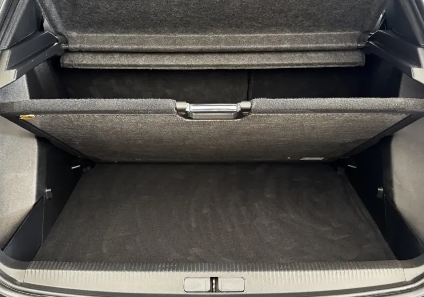 Vue plongeante sur le coffre gris foncé du Peugeot 2008 2022 avec plancher de coffre relevé et compartiment de rangement visible.