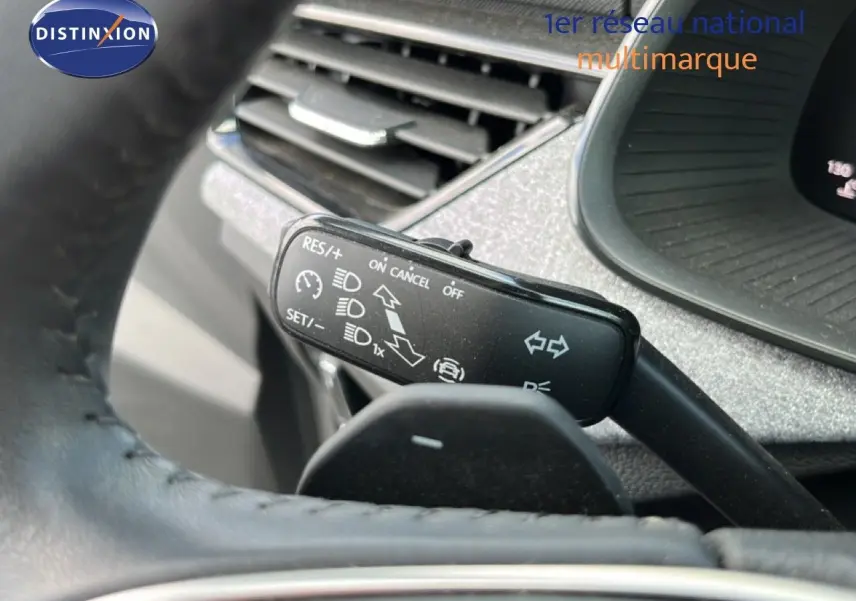 Gros plan sur la commande de régulateur de vitesse et clignotants dans l’habitacle gris noir d’une Skoda Scala 2025.