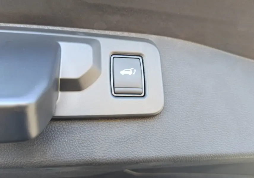 Bouton d'ouverture électrique du coffre sur la garniture intérieure du hayon du Renault Austral blanc esprit Alpine.