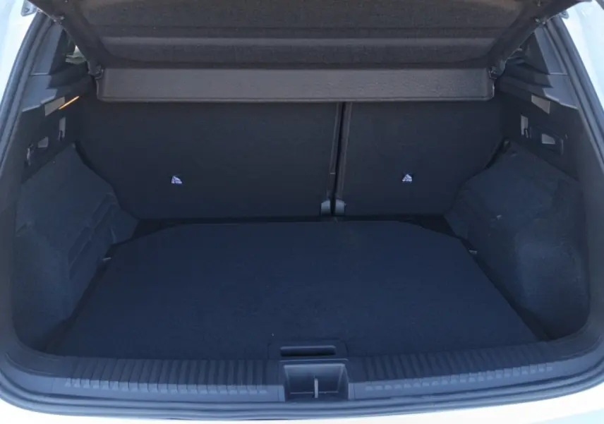 Coffre ouvert vu de l'arrière d'un Renault Austral blanc, montrant un espace de chargement propre et spacieux.