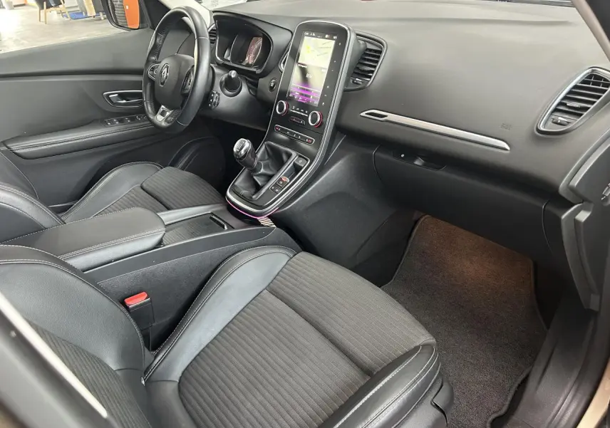 Intérieur côté conducteur du Renault Scénic Grand IV 2017, avec sellerie mixte noire et console centrale tactile verticale.