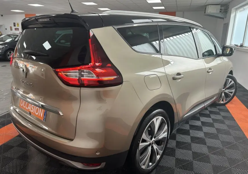 Vue 3/4 arrière droite d'un Renault Scénic Grand IV marron clair avec toit noir panoramique et jantes alliage 20 pouces.