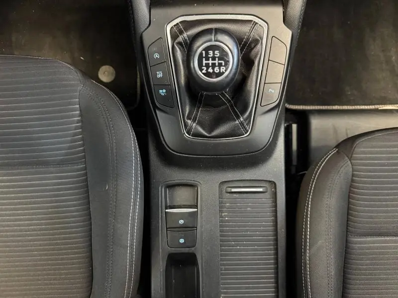 Vue de dessus du levier de vitesses manuel noir et console centrale entre les sièges avant en tissu gris de la Ford Focus Titanium X Business 2021.
