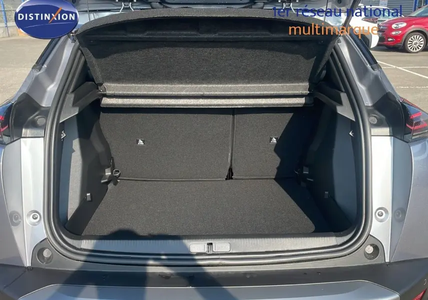 Coffre ouvert vu de l'arrière d'un Peugeot 2008 gris Artense Metal, montrant l'espace de chargement vide.