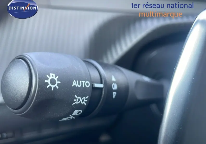 Gros plan sur la commande des phares à gauche du volant dans l'habitacle du Peugeot 2008 gris Artense 2025.