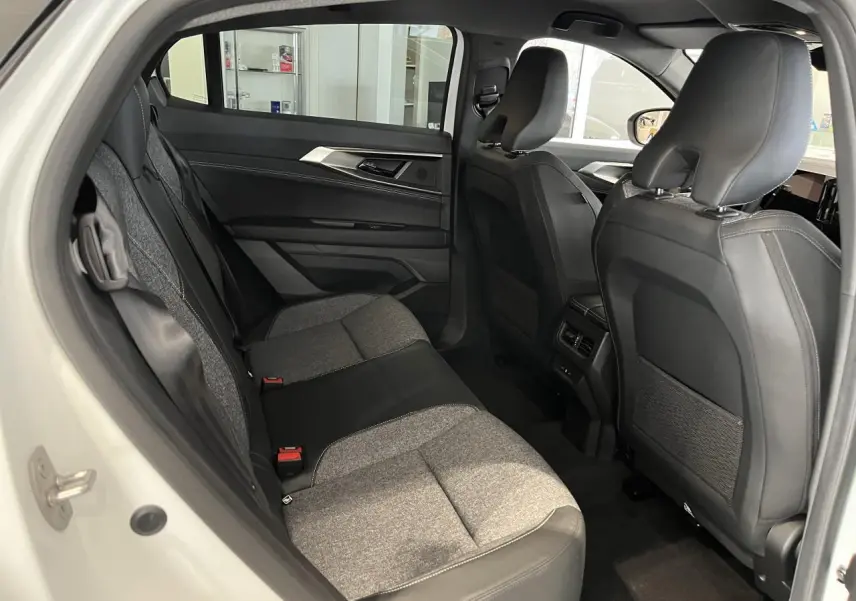 Vue intérieure côté gauche des sièges arrière gris clair et noir du Renault Rafale blanc 2025 avec finitions textiles et cuir.