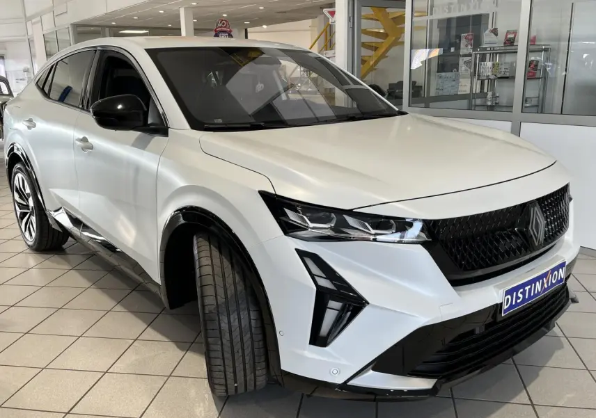 Vue 3/4 avant droite du Renault Rafale blanc 2025 avec calandre noire et jantes alliage noires diamantées.