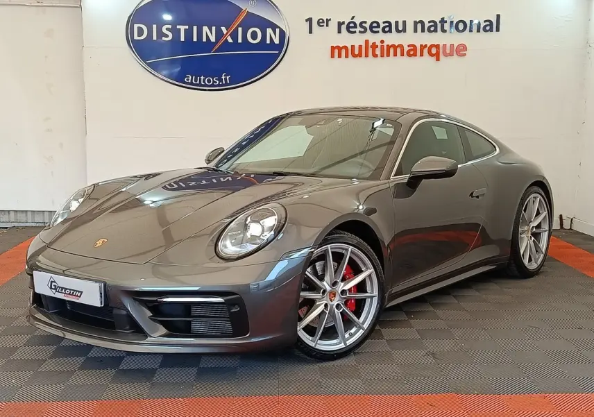 Vue 3/4 avant droite d'une Porsche 911 Carrera 4S Coupé gris foncé avec jantes alliage et étriers de frein rouges.