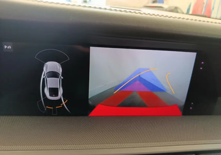 Écran tactile intérieur affichant la caméra de recul et le capteur de stationnement d'une Porsche 911 gris foncé.