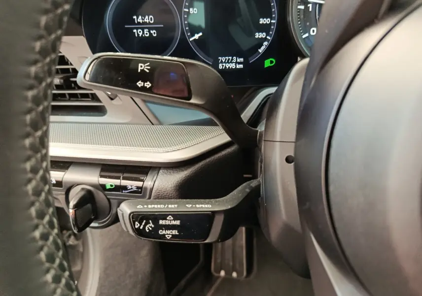 Détail du combiné d'instruments et commandes au volant d'une Porsche 911 Carrera 4S Coupé gris foncé, vue côté conducteur.