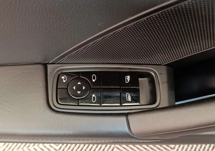 Gros plan sur les commandes électriques des rétroviseurs et vitres côté gauche d’une Porsche 911 Carrera 4S Coupé gris foncé.