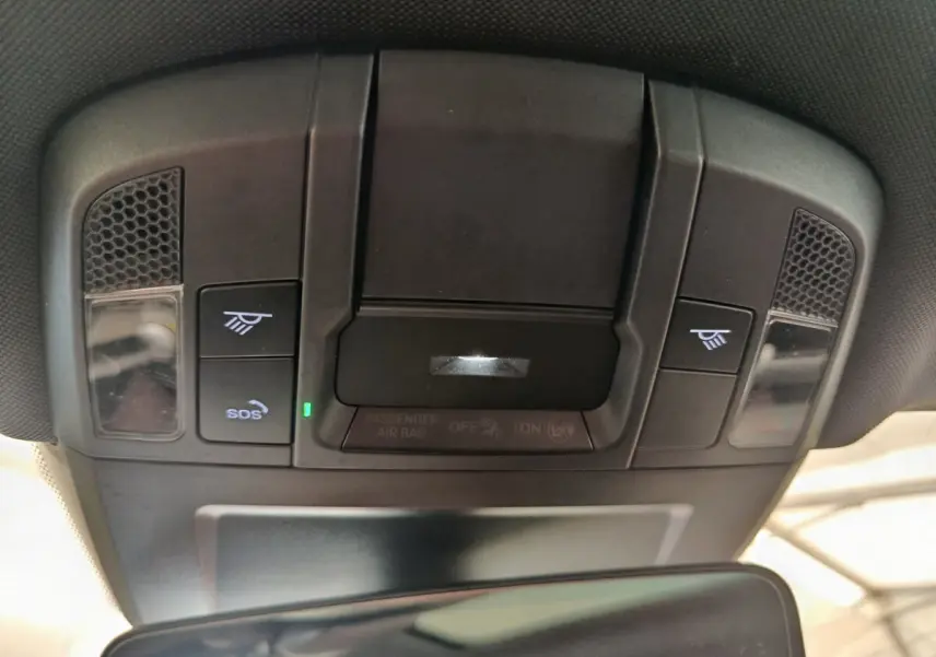 Vue intérieure du plafonnier noir avec commandes d'éclairage et bouton SOS dans une Porsche 911 Carrera 4S Coupé gris foncé.