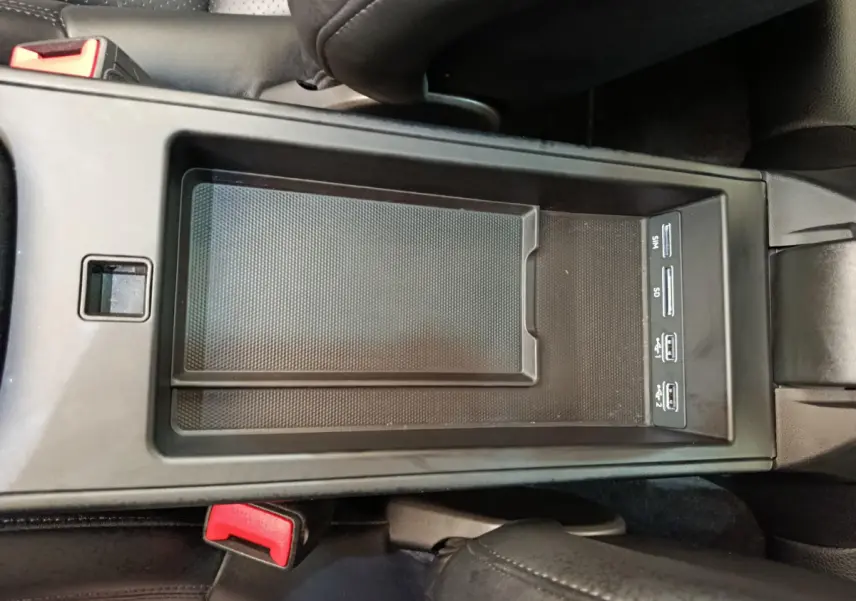 Vue plongeante sur la console centrale noire de la Porsche 911 Carrera 4S Coupé 2019 avec ports USB et rangement intégré.
