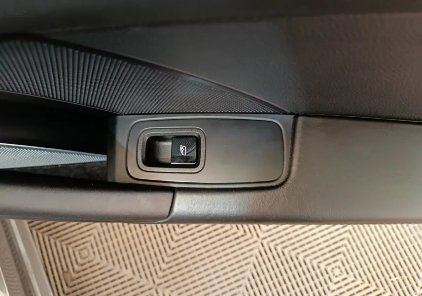 Gros plan sur le bouton de commande de la vitre côté conducteur, intérieur cuir noir de la Porsche 911 Carrera 4S 2019.