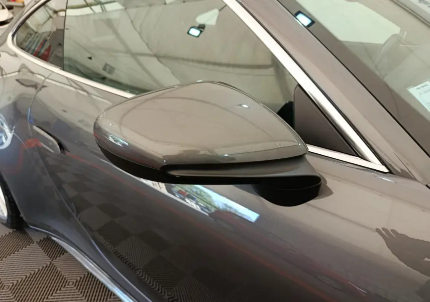 Gros plan sur le rétroviseur côté gauche gris foncé d'une Porsche 911 Carrera 4S Coupé 2019, avec reflet du véhicule.