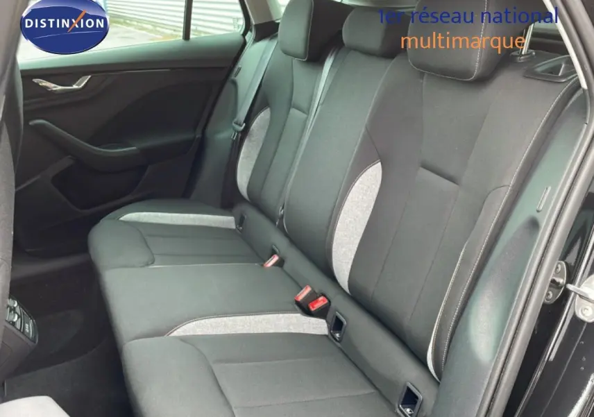 Vue intérieure côté droit montrant la banquette arrière en tissu gris et noir d'une Skoda Scala noir magique métal.