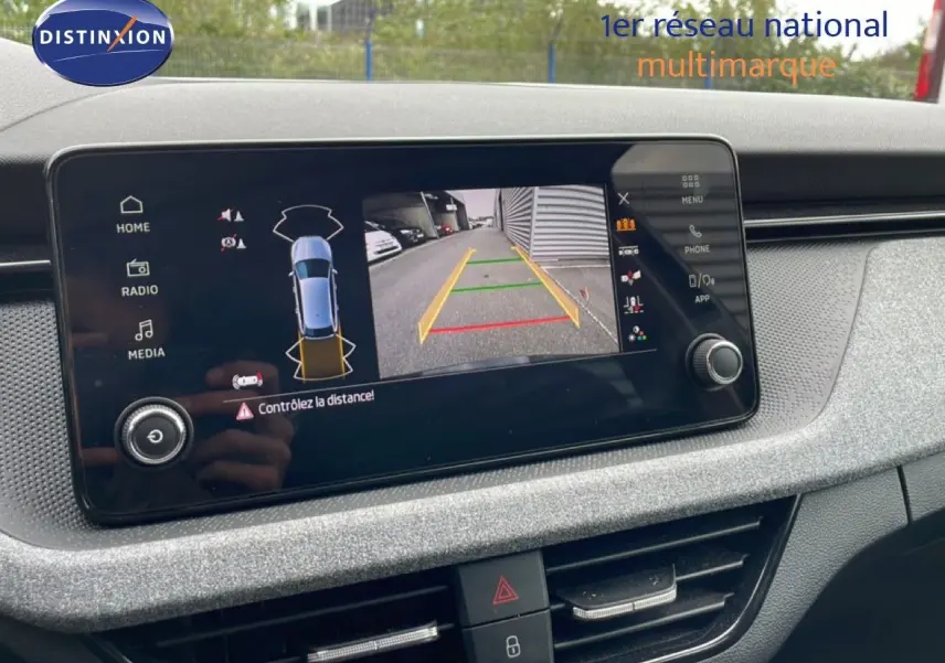 Écran central de la Skoda Scala 2025 montrant la caméra de recul avec guidage de trajectoire, tableau de bord gris clair.