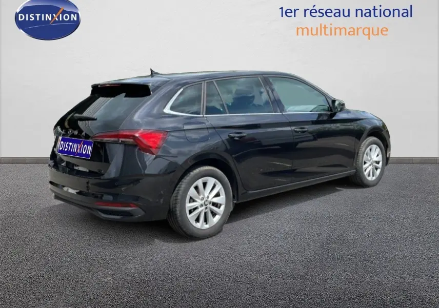 Vue 3/4 arrière droite d’une Skoda Scala noire métallisée avec jantes argentées sur fond neutre.