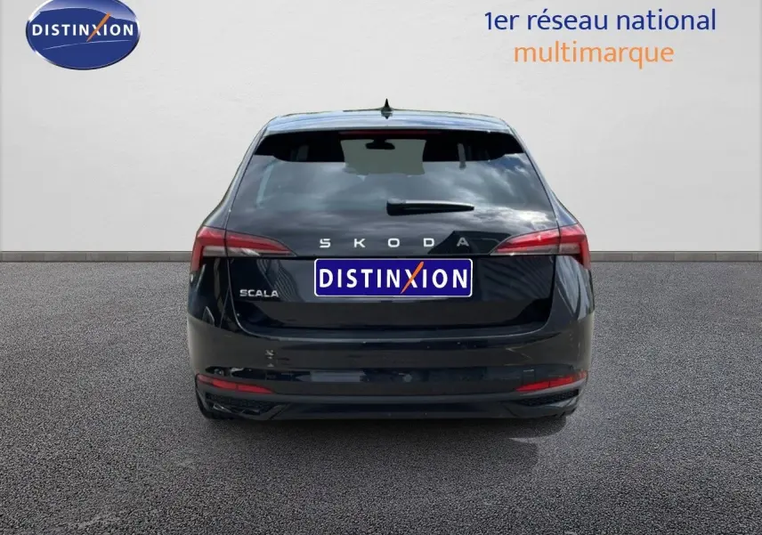 Vue arrière d'une Skoda Scala noire métal, avec feux arrière allongés et logo distinctif bien visible.