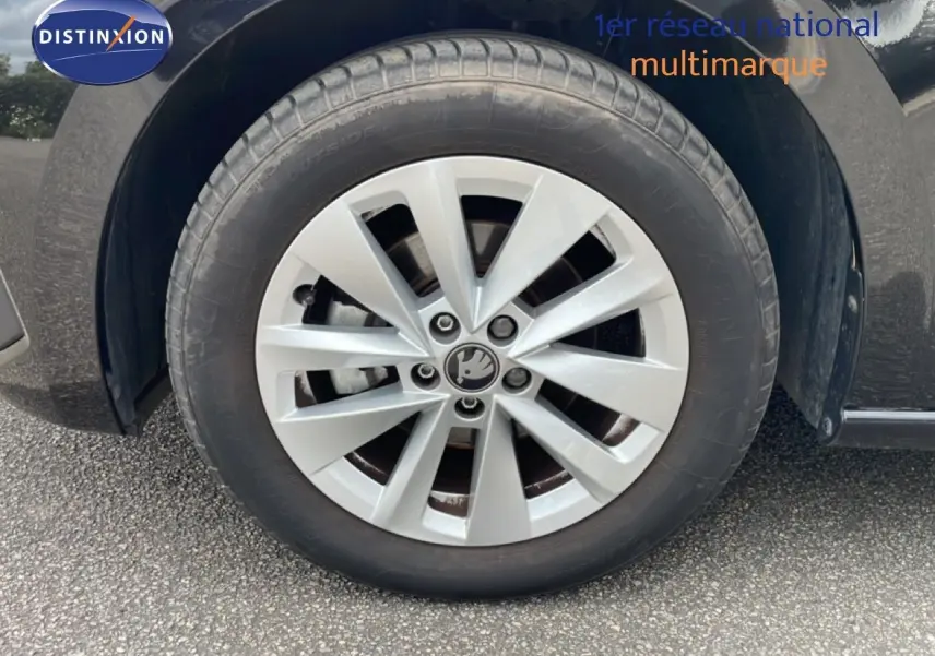 Gros plan sur la roue avant droite d'une Skoda Scala noire avec jante alliage argentée au design moderne.