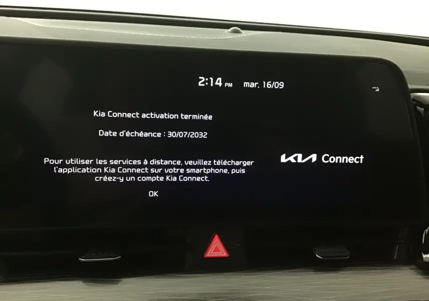 Écran digital 12,3'' du Kia Sportage 2025 affichant l'activation de Kia Connect avec bouton d'alerte rouge en dessous.