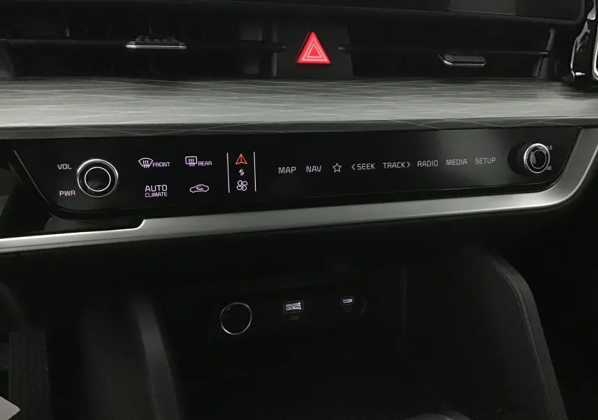 Détail du tableau de bord du Kia Sportage 2025 blanc, avec écran digital 12,3 pouces et commandes tactiles éclairées.