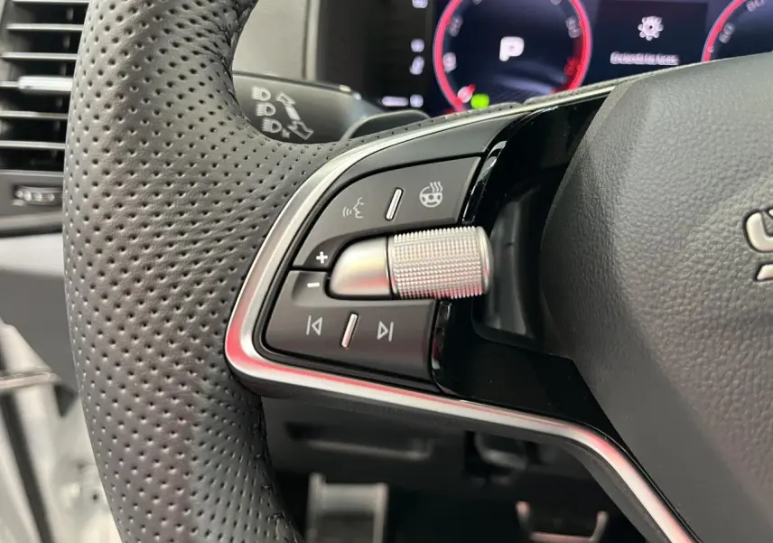 Gros plan sur les commandes multifonctions en aluminium du volant perforé noir du Skoda Karoq 2025 Sportline.