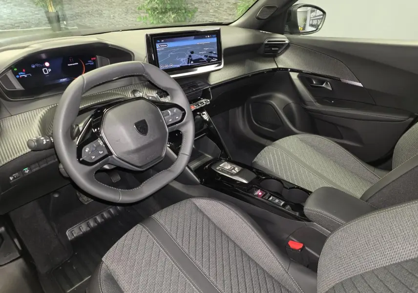 Vue intérieure avant droite du Peugeot 2008 2025 gris, avec tableau de bord numérique et écran tactile central.