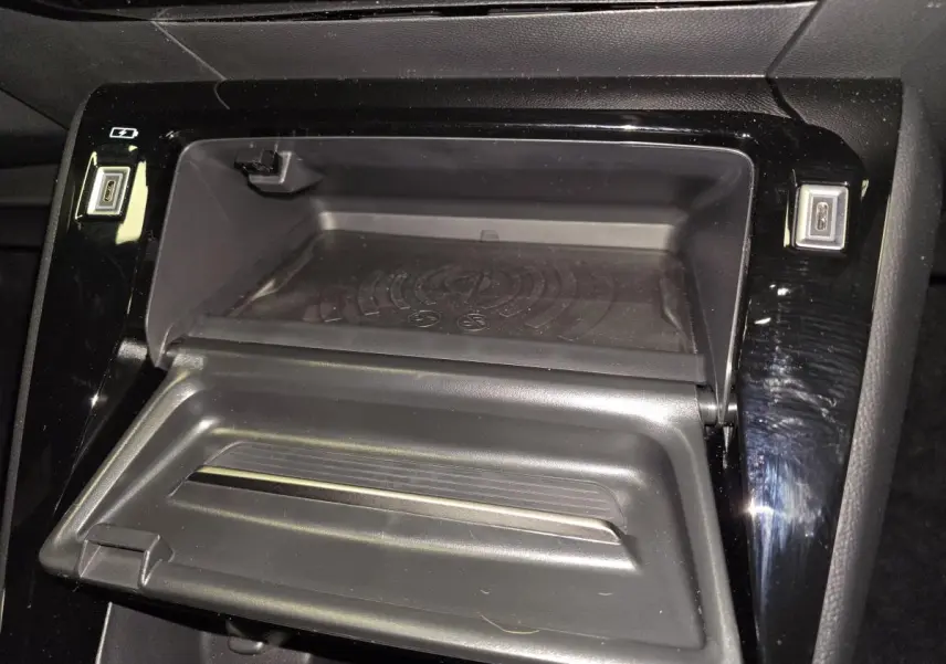 Vue rapprochée de la console centrale noire du Peugeot 2008 2025, avec compartiment ouvert et prises USB visibles.