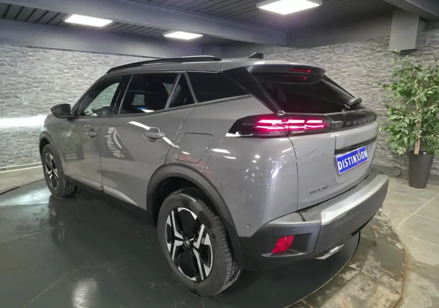 Vue 3/4 arrière droite du Peugeot 2008 gris métallisé avec feux arrière LED 3 griffes et jantes alliage 17'' bi-ton.