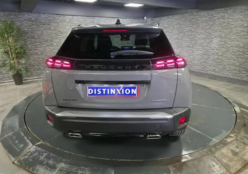 Vue arrière d'un Peugeot 2008 gris 2025 avec feux arrière LED 3 griffes et double canule d'échappement chromée.