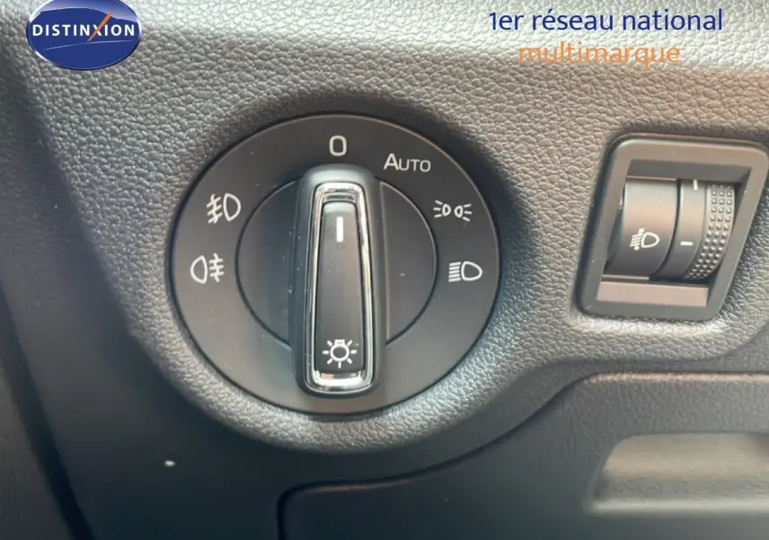 Gros plan sur la molette de réglage des phares dans l'habitacle d'une Skoda Scala blanc glacier, version 2025.