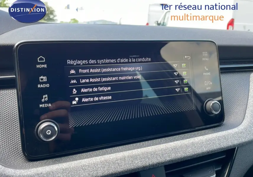 Écran tactile du tableau de bord de la Skoda Scala blanc glacier, affichant les réglages d’aide à la conduite.