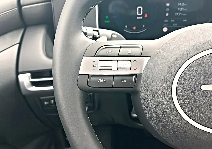 Gros plan sur le volant cuir multifonction gris du Hyundai Tucson 2026 avec commandes intégrées et tableau de bord digital.