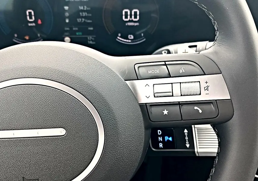 Gros plan sur le volant cuir multifonction du Hyundai Tucson 2026, avec commandes audio et levier de vitesses digital.