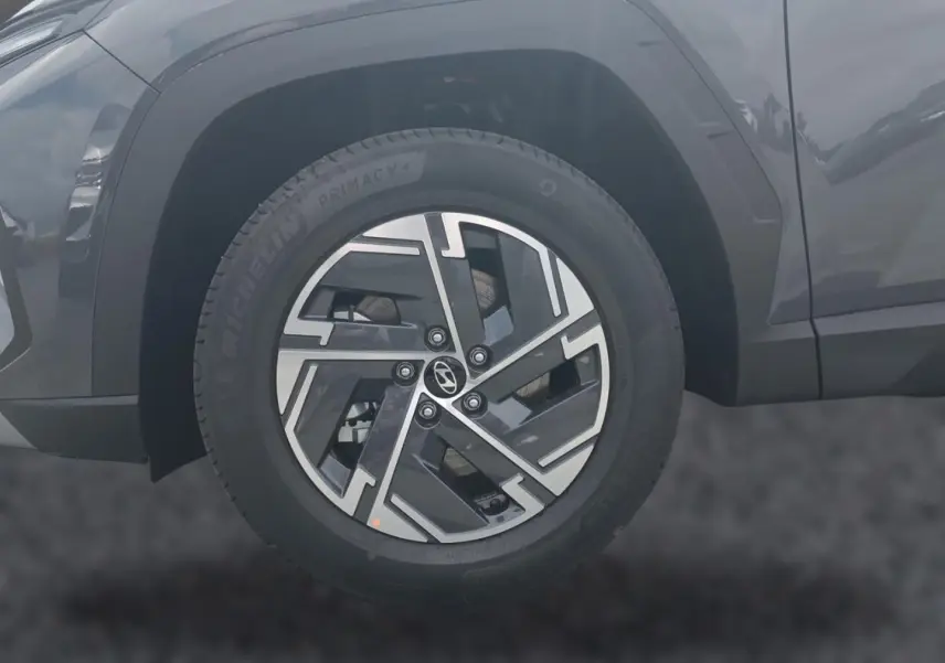 Gros plan sur la roue avant gauche du Hyundai Tucson gris ecotronique avec jante alliage 17 pouces au design moderne.